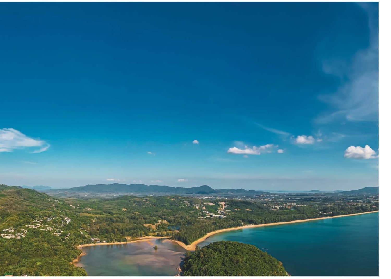 Layan bay on Phuket's west coast with the forested hills behind, the slopes on which the 2024 environmental-protection notice limits what may be built above 40, 80 and 140 metres
