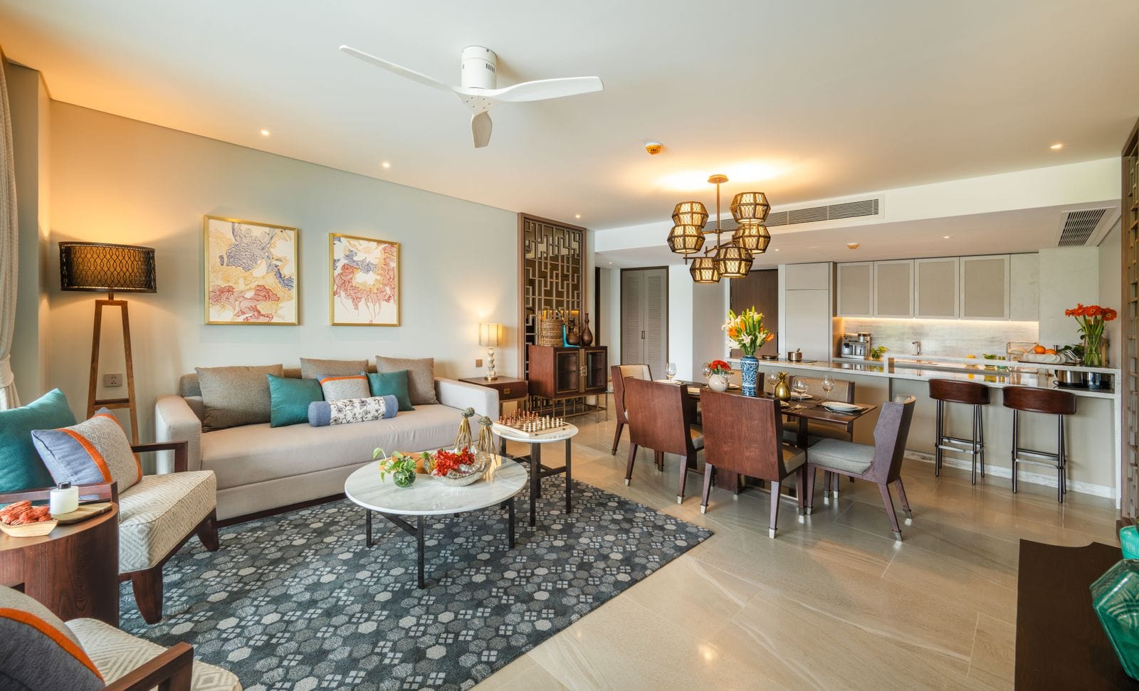 Photograph of the living room, dining table and kitchen of home 312, a finished two-bedroom in Building 3 at Angsana Oceanview Residences, furnished. October 2025