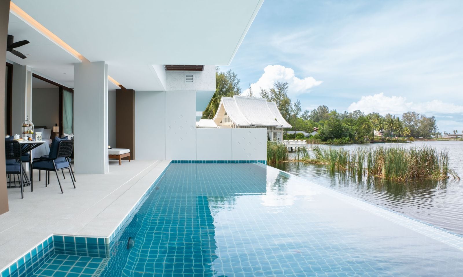 Photograph of the private pool of home 312, a finished two-bedroom in Building 3 at Angsana Oceanview Residences, running to the lagoon edge, with the white pavilion beyond. October 2025