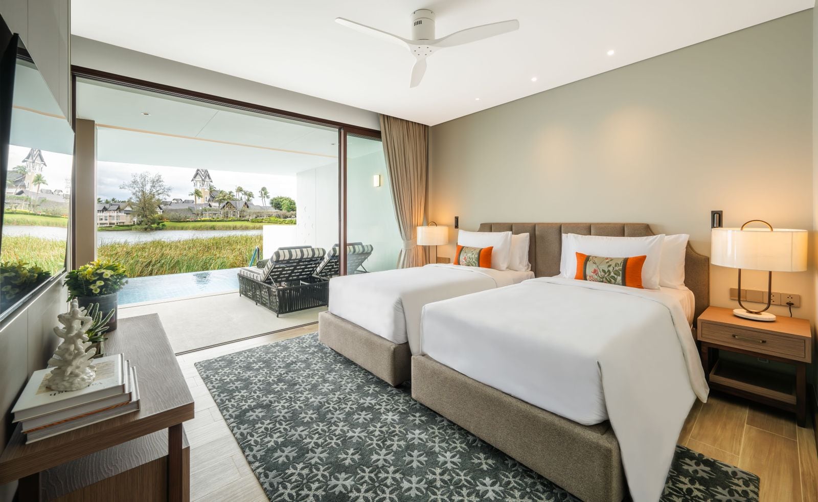 Photograph of the second bedroom of home 312, a finished two-bedroom in Building 3 at Angsana Oceanview Residences, with two beds and glass to the terrace and the lagoon. October 2025