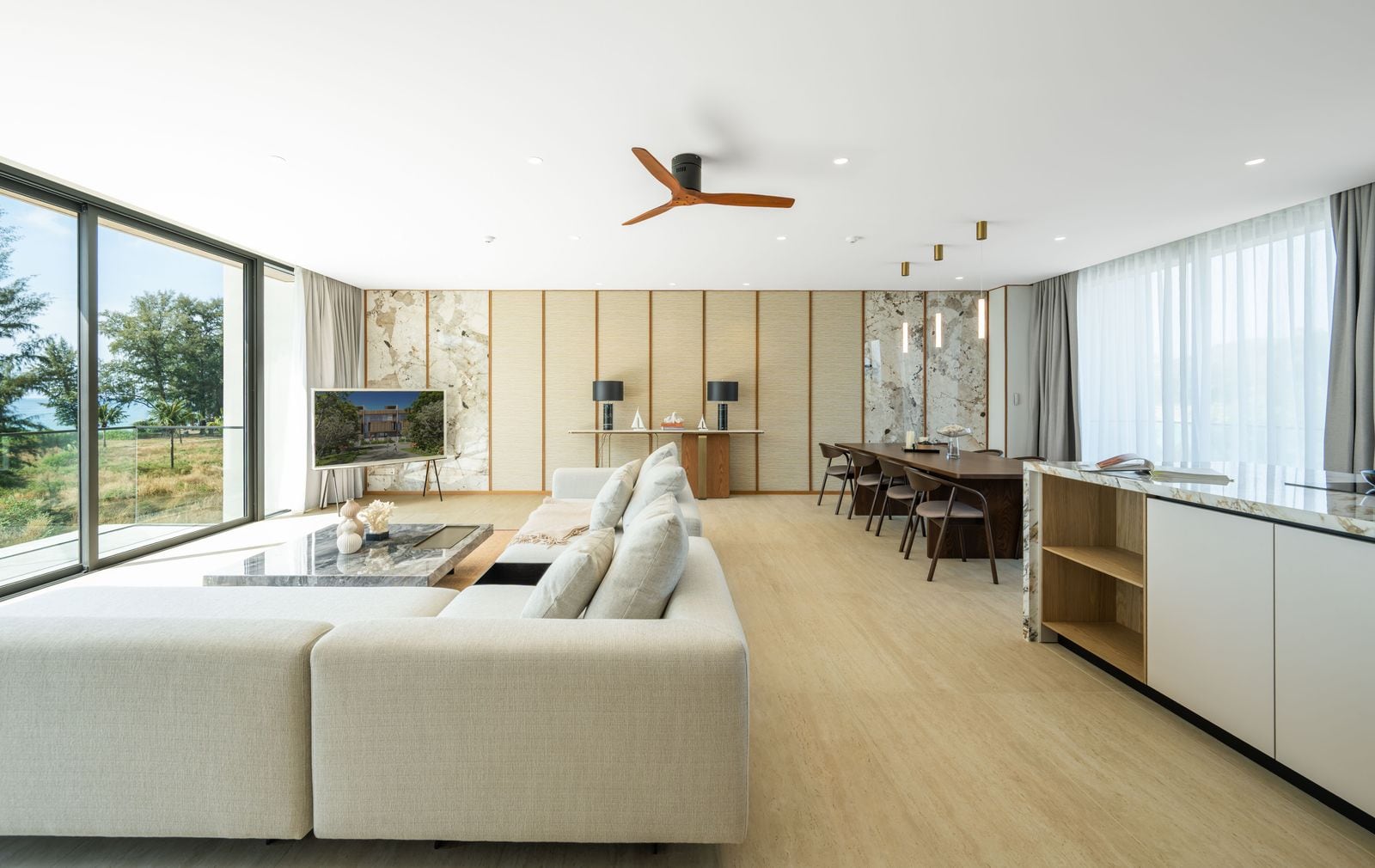 Banyan Tree Beach Residences Nammu 一個已完工聯排住宅第三層客廳的照片,攝於 2026 年 1 月:大型沙發,兩面玻璃,外面是樹林