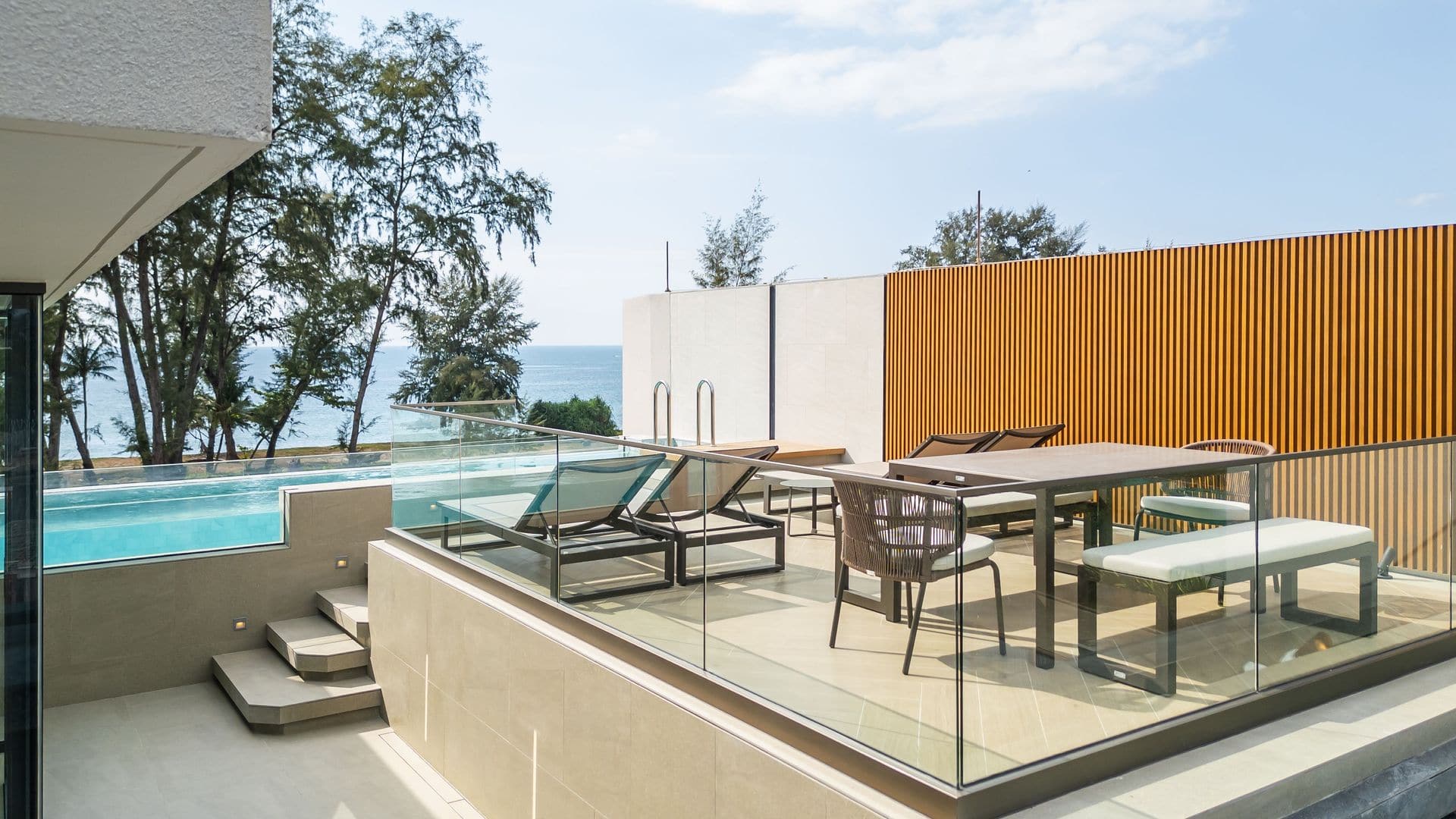 Banyan Tree Beach Residences Nammu 一個已完工天台的照片,攝於 2026 年 1 月:私人泳池、玻璃欄河後的用餐平台及燒烤爐,遠處是木麻黃樹及大海