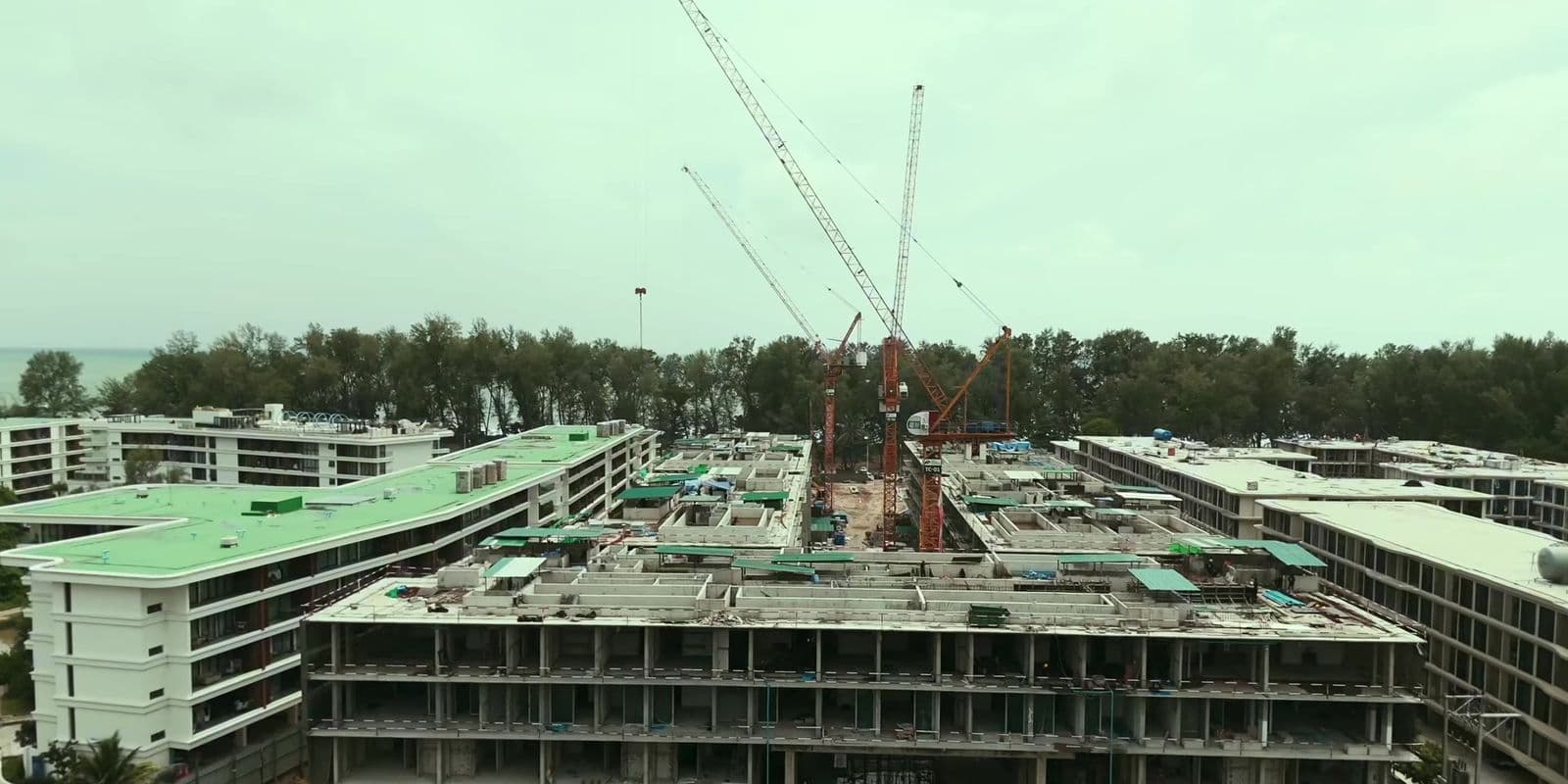 The buildings of Eden Residences, Gardens of Eden, Phuket, from the air in August 2026, with cranes over the upper floors being finished