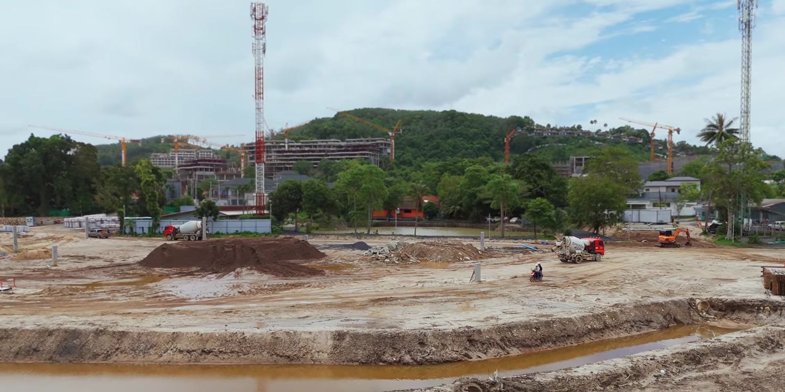 The site of Lake Residences, Gardens of Eden, Phuket, in August 2026, cleared and with piling begun, with the hills behind
