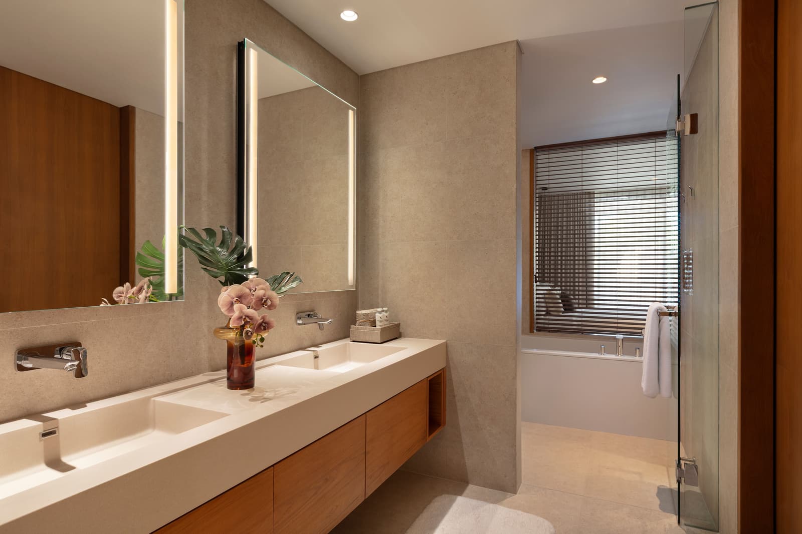 Bathroom of the three-bedroom show condominium at Kiara Reserve Residences, Phuket, long stone counter and mirror wall