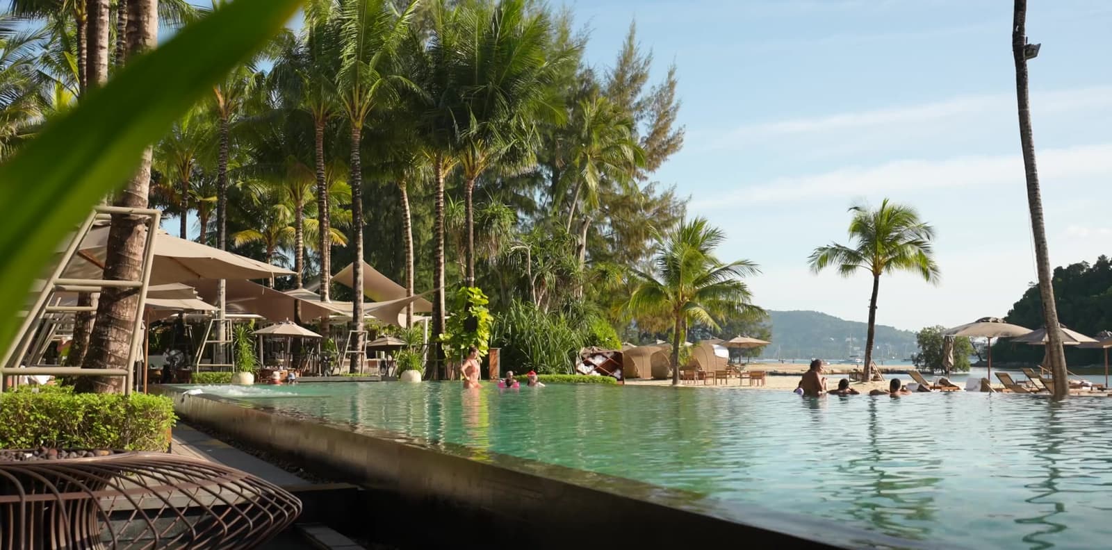 Бассейн Beach House by Anantara на пляже Layan, Пхукет, пальмы и море позади, под Kiara Reserve Residences