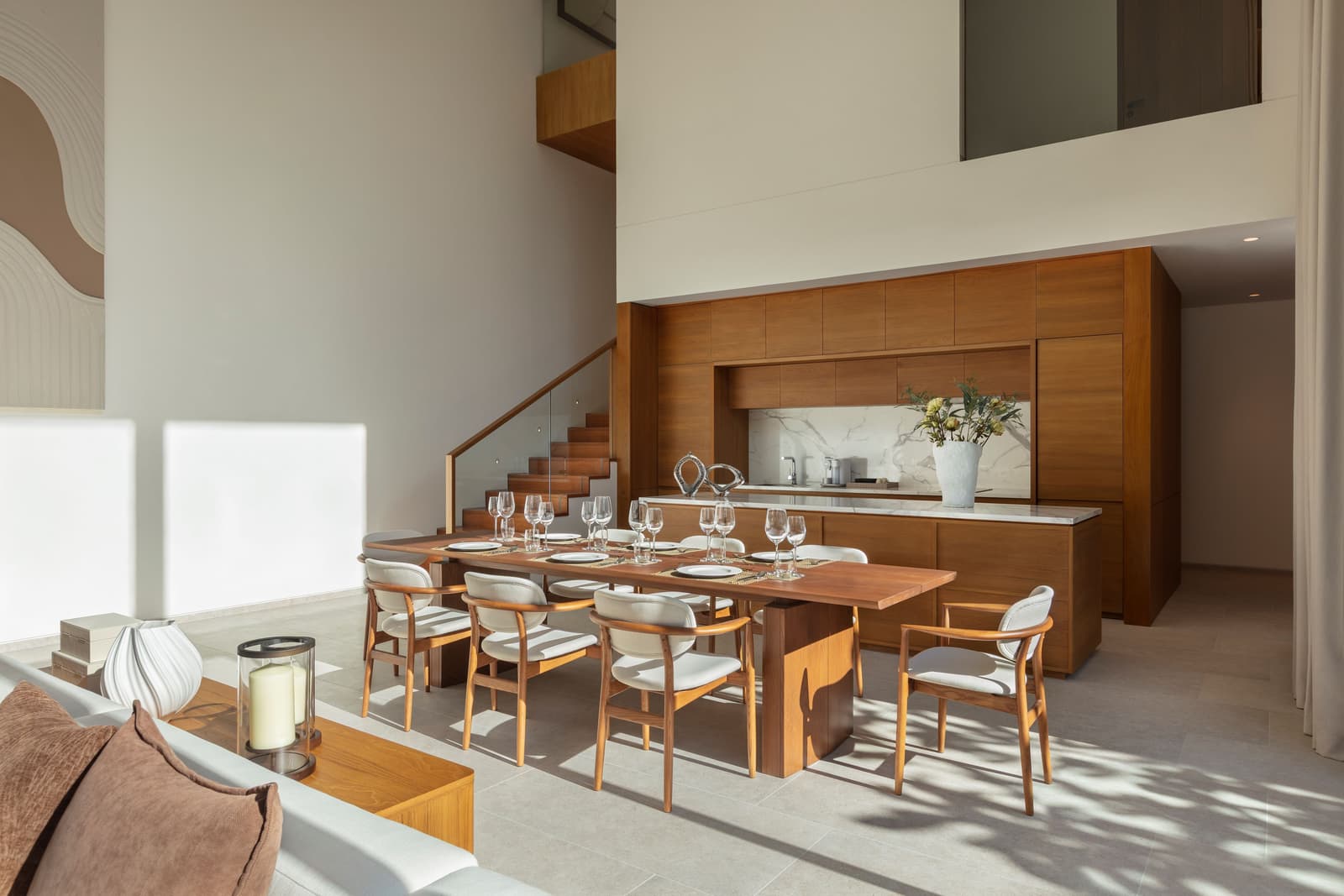 ห้องรับประทานอาหารของวิลลาตัวอย่าง 4 ห้องนอนที่ Kiara Reserve Residences ภูเก็ต โต๊ะไม้สักใต้โถงเพดานสูงสองชั้น