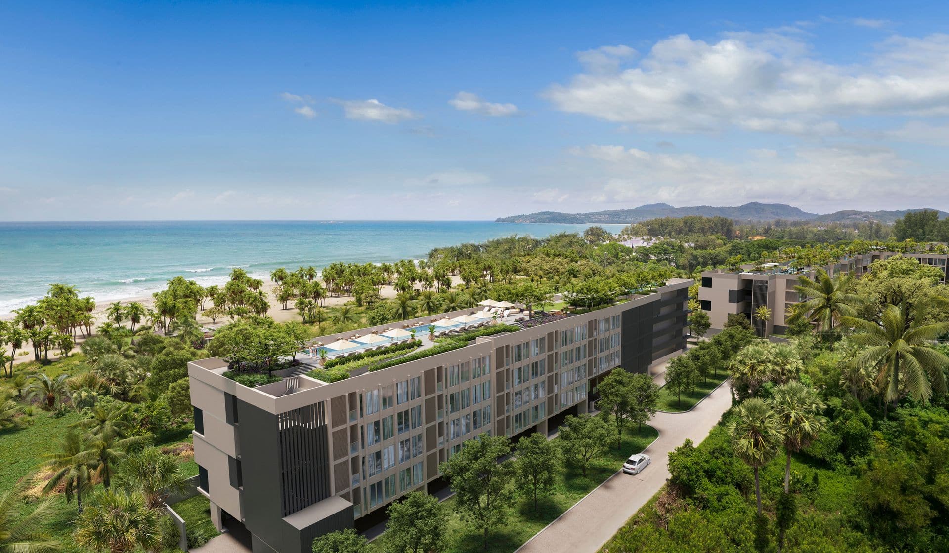 Визуализация на снимке с дрона Laguna Beach Residences Seashore: пятиэтажный корпус с бассейном на крыше среди пальм Laguna Phuket, дальше пляж Bang Tao и море, позади корпуса Reef