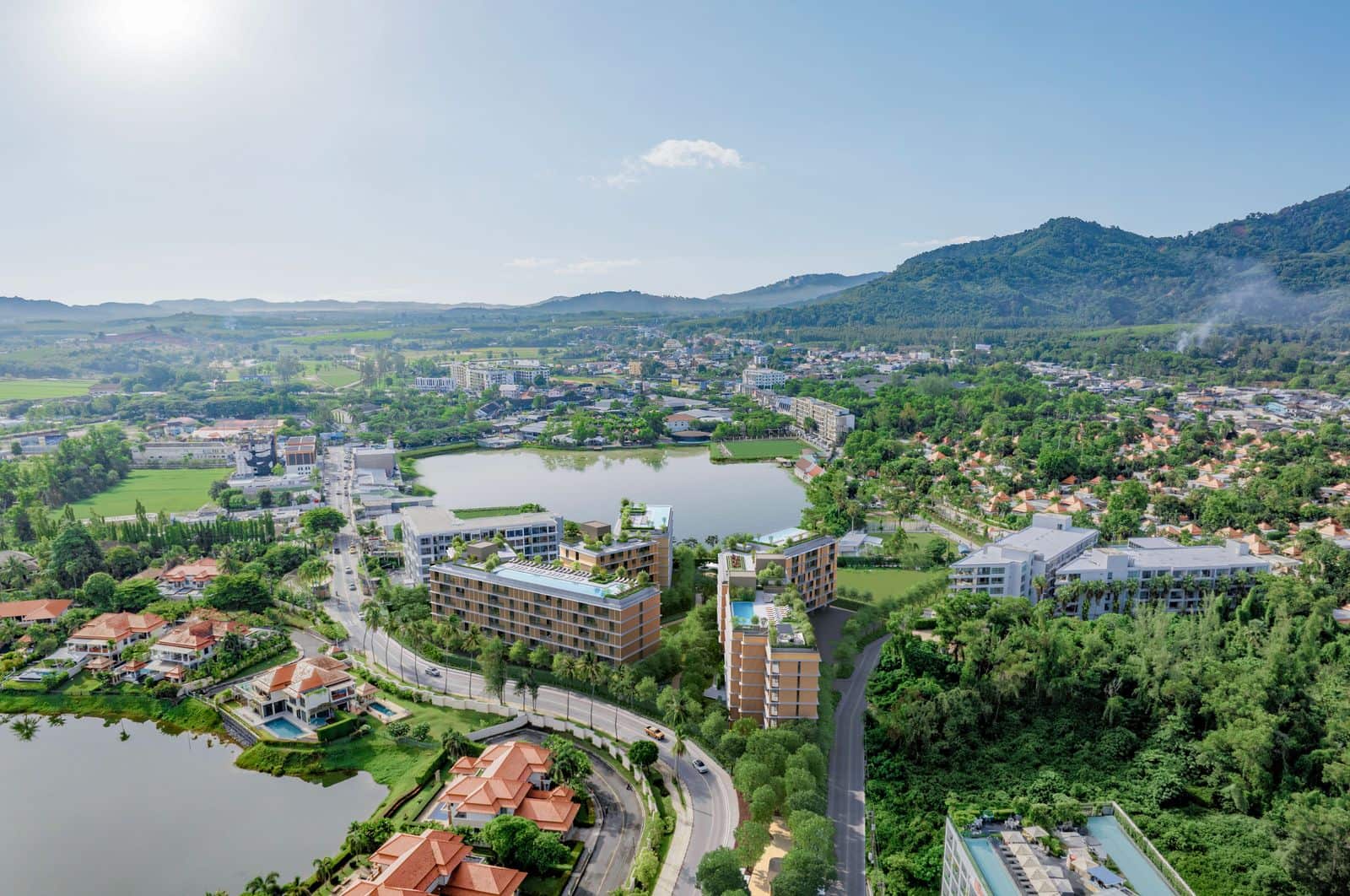 ภาพมุมสูงจาก Laguna Lake Residences Aster มองเข้าไปทางแผ่นดินสู่เนินเขาของภูเก็ต: ภาพถ่ายโดรนของผู้พัฒนาที่ใส่อาคารเป็นภาพจำลอง