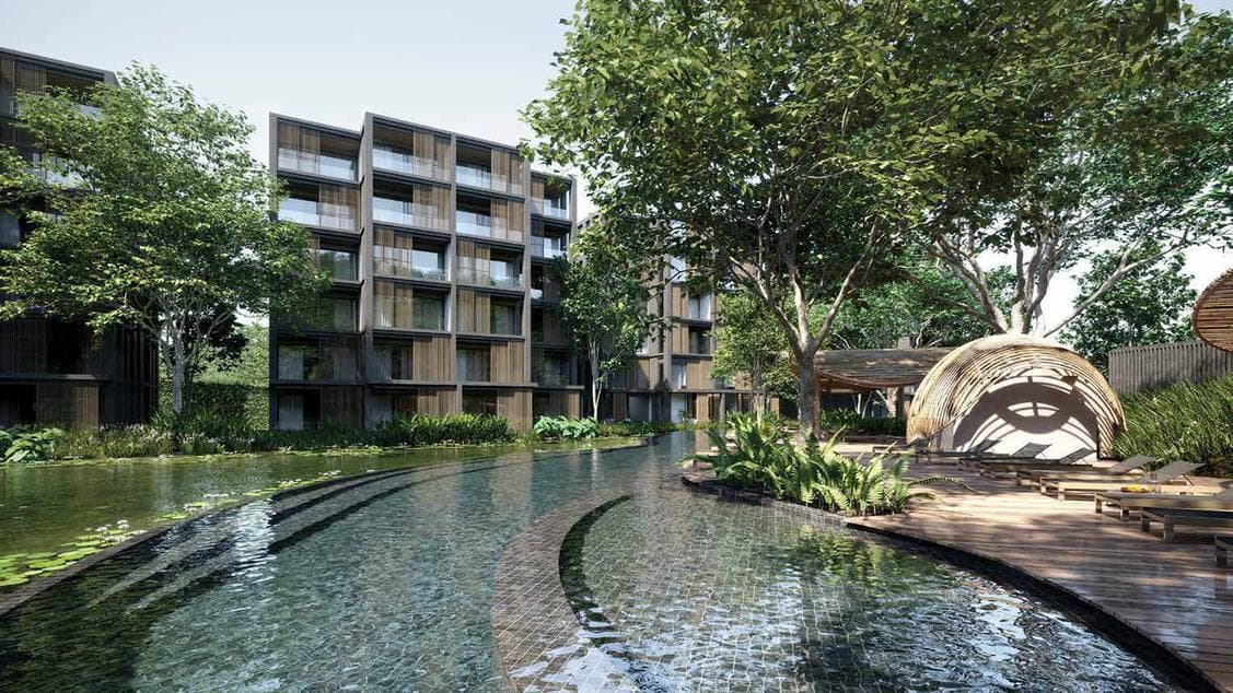ภาพจำลองจากคอมพิวเตอร์ของ MGallery Residences MontAzure Lakeside ย่าน Kamala ภูเก็ต: สระโค้งที่มีขั้นบันไดปูกระเบื้องทอดลงสู่ทะเลสาบบัว ศาลาหวายบนพื้นไม้ และอาคารหกชั้นหลังแนวต้นไม้