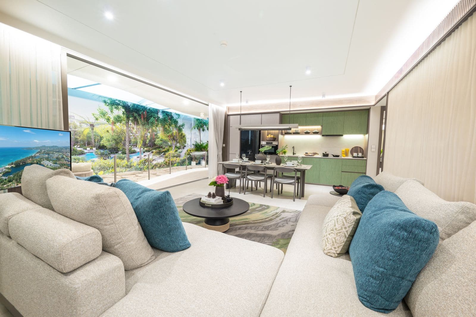 Residences at Garrya Phuket 連家具兩房樣品屋客廳的實景照片:米色沙發配藍色靠墊,餐桌放在向花園的窗前