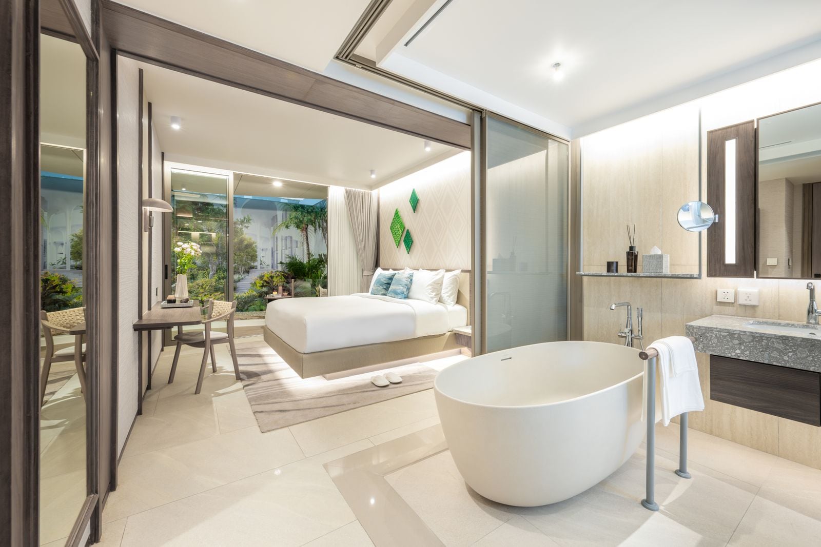 Residences at Garrya Phuket 兩房樣品屋主人臥室的實景照片:床邊是獨立式浴缸,玻璃外是花園