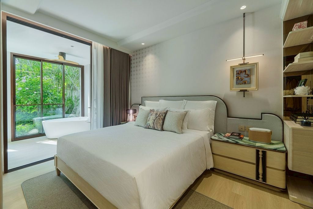 Bedroom of the furnished one-bedroom show unit of The Residences at InterContinental Phuket Resort, a wide window onto the garden