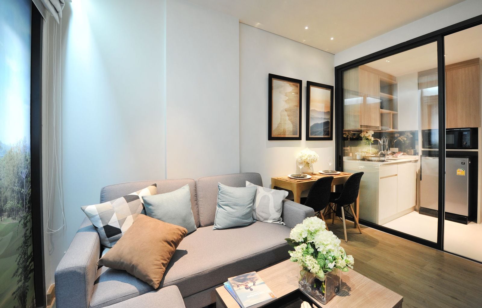 Skypark Celeste Laguna Phuket 1B 型示範單位客廳的相片,後方是廚房