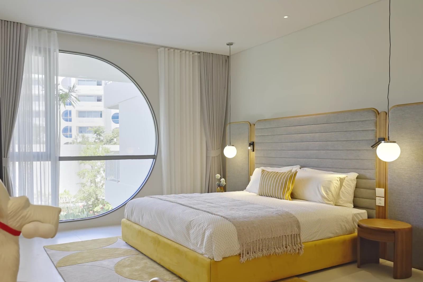 ห้องนอนใหญ่ของดูเพล็กซ์ตัวอย่างที่ The Standard Residences, Phuket Bang Tao บนชั้นบน พร้อมหน้าต่างทรงกลม