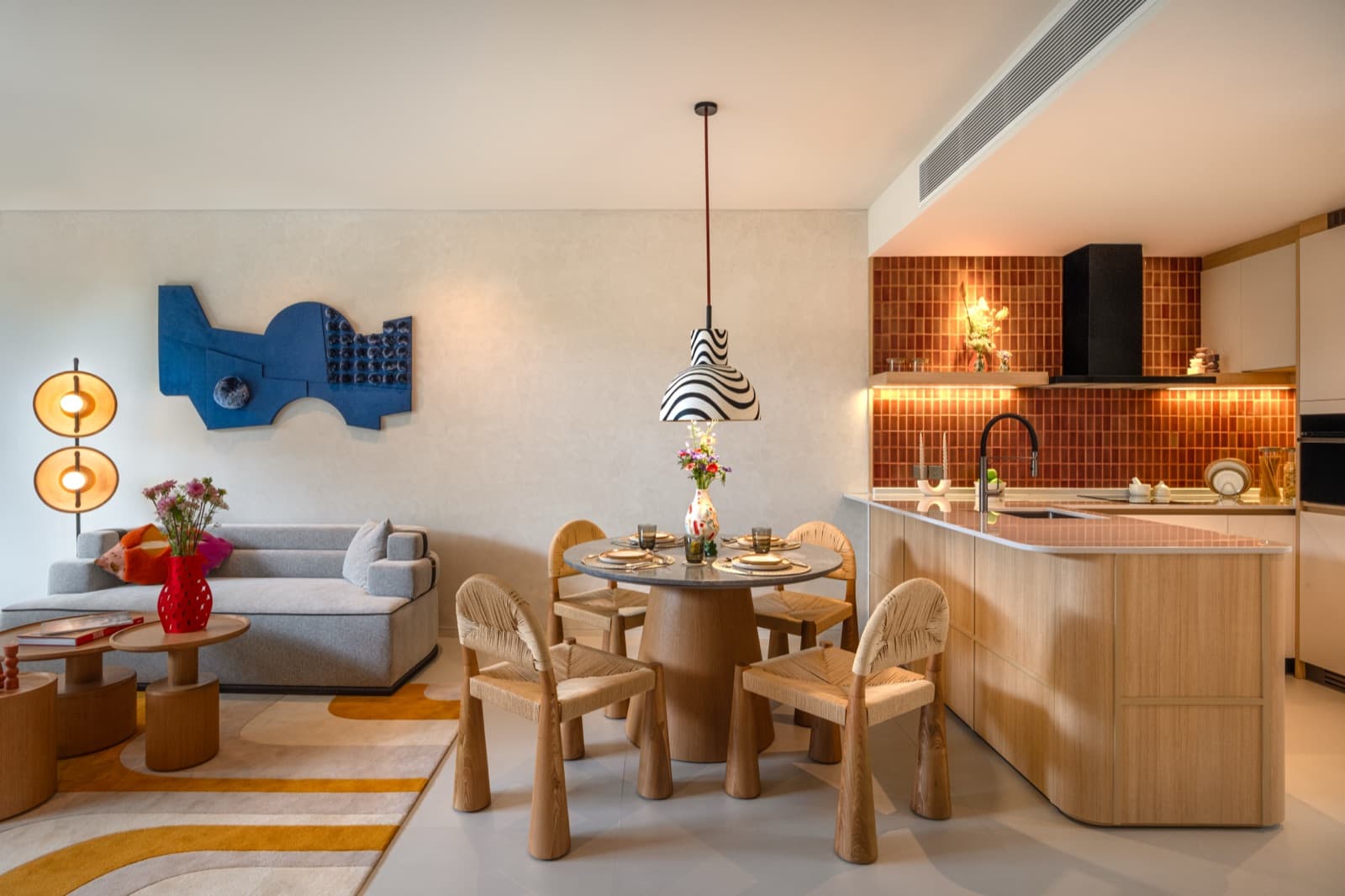 ครัวและโต๊ะรับประทานอาหารของห้องตัวอย่าง 1 ห้องนอนที่ The Standard Residences, Phuket Bang Tao พร้อมกระเบื้องสีแดงและเคาน์เตอร์ไม้