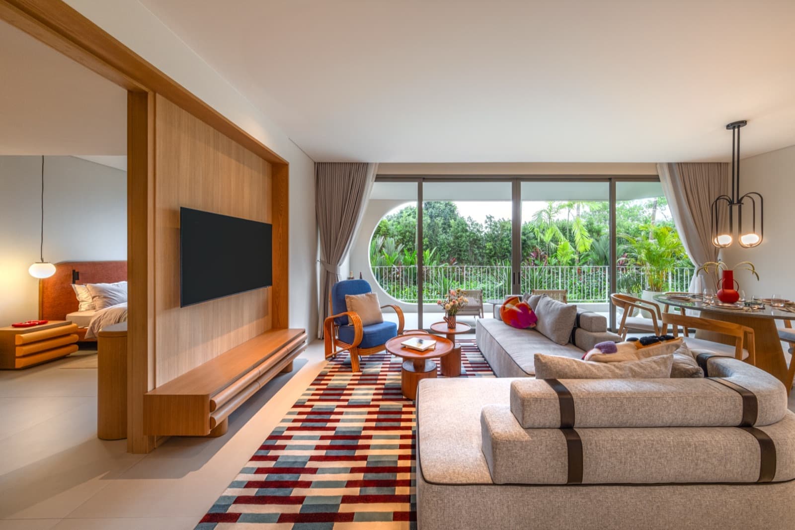 Гостиная шоу-квартиры большой планировки с двумя спальнями в The Standard Residences, Phuket Bang Tao: серые диваны, узорчатый ковёр и стеклянные двери на балкон
