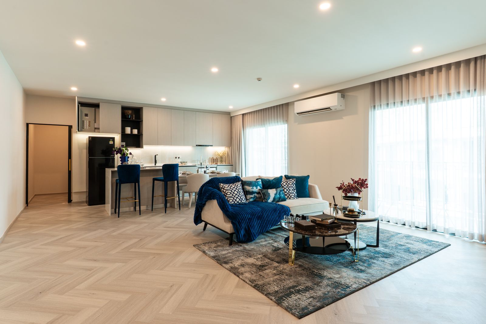 The finished penthouse show unit at The Title Heritage Bang-Tao, Phuket: a long living room with an open kitchen and a dining bar