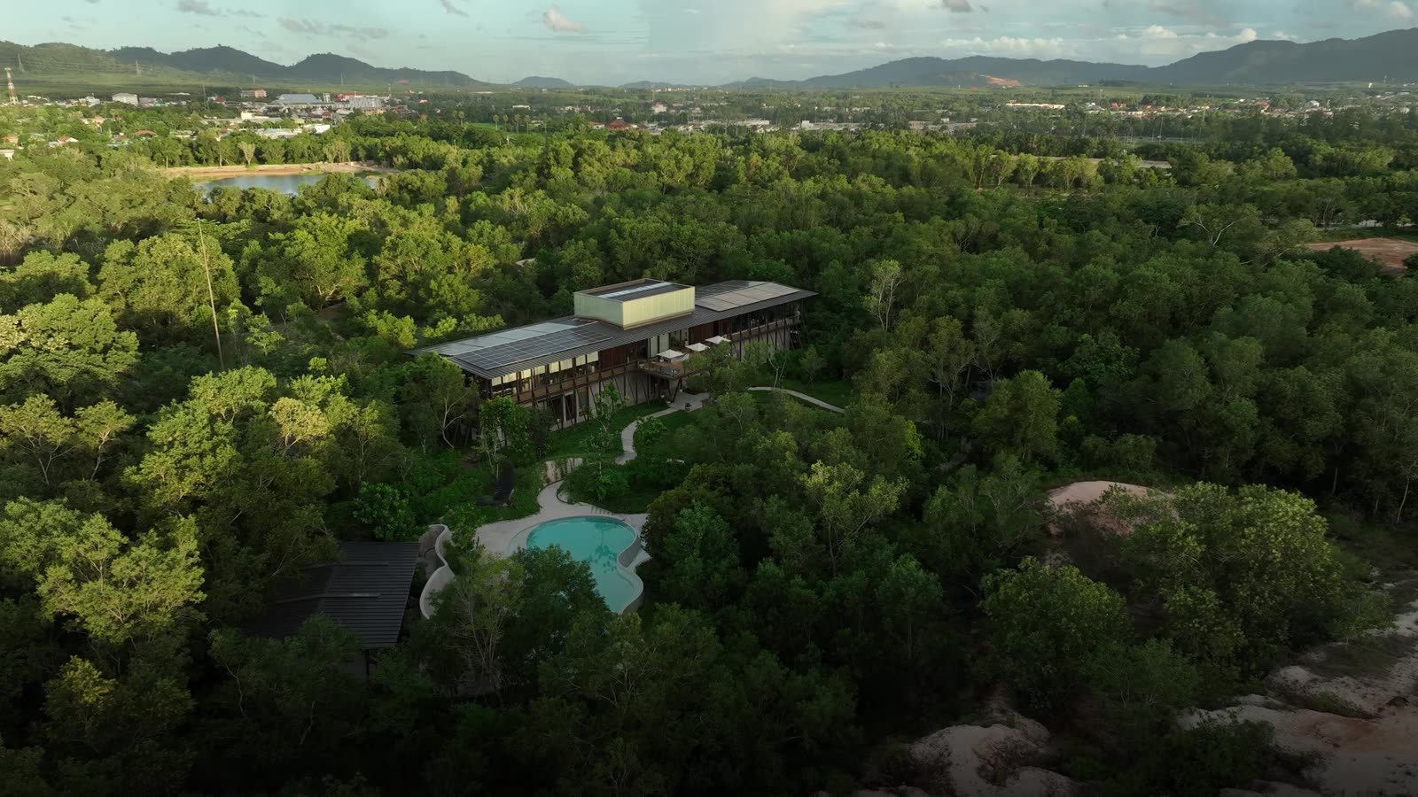 Aerial view of Tri Vananda, Phuket: villas among forest and lakes, the hills behind