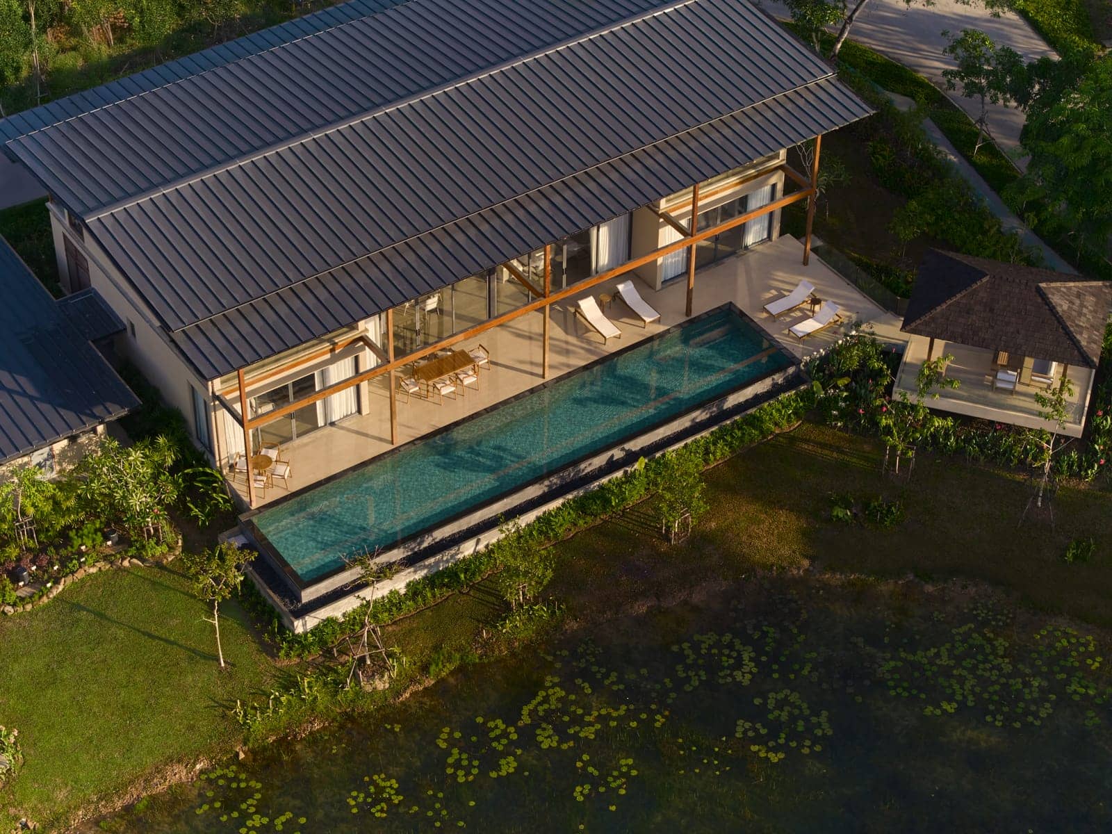 The Vana 4 show villa at Tri Vananda, Phuket, from the air: its 20-metre pool running along the house towards the lake