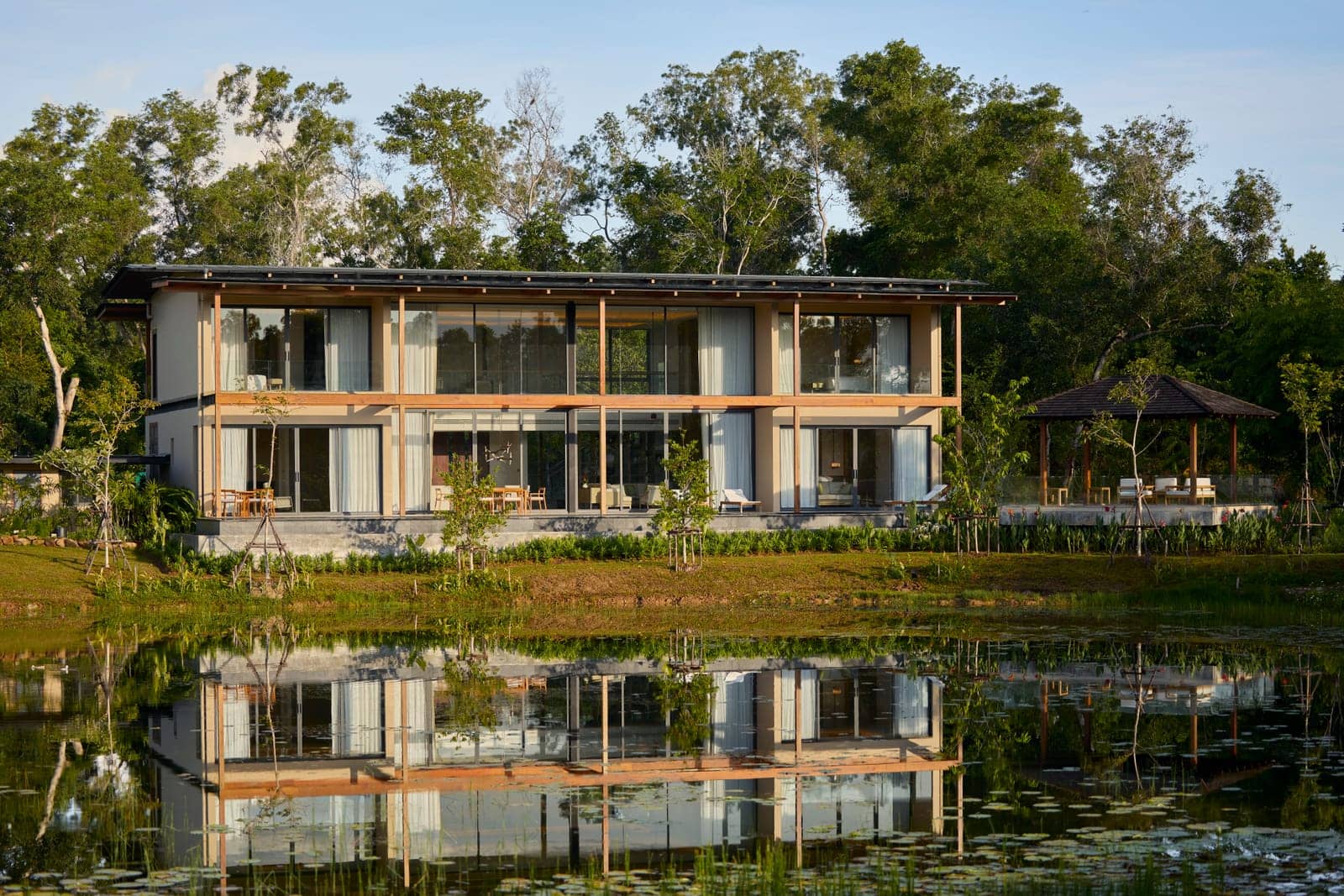 The Vana 4 show villa at Tri Vananda, Phuket, seen across its lake among the trees