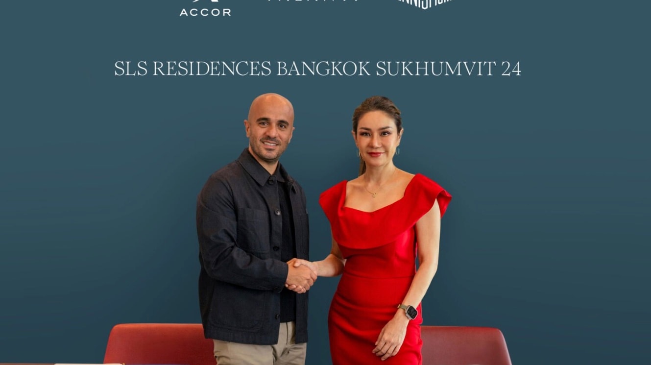 高層在 SLS Residences Bangkok Sukhumvit 24 的簽約公布儀式上握手,背景是 Accor 與 Ennismore 的標誌