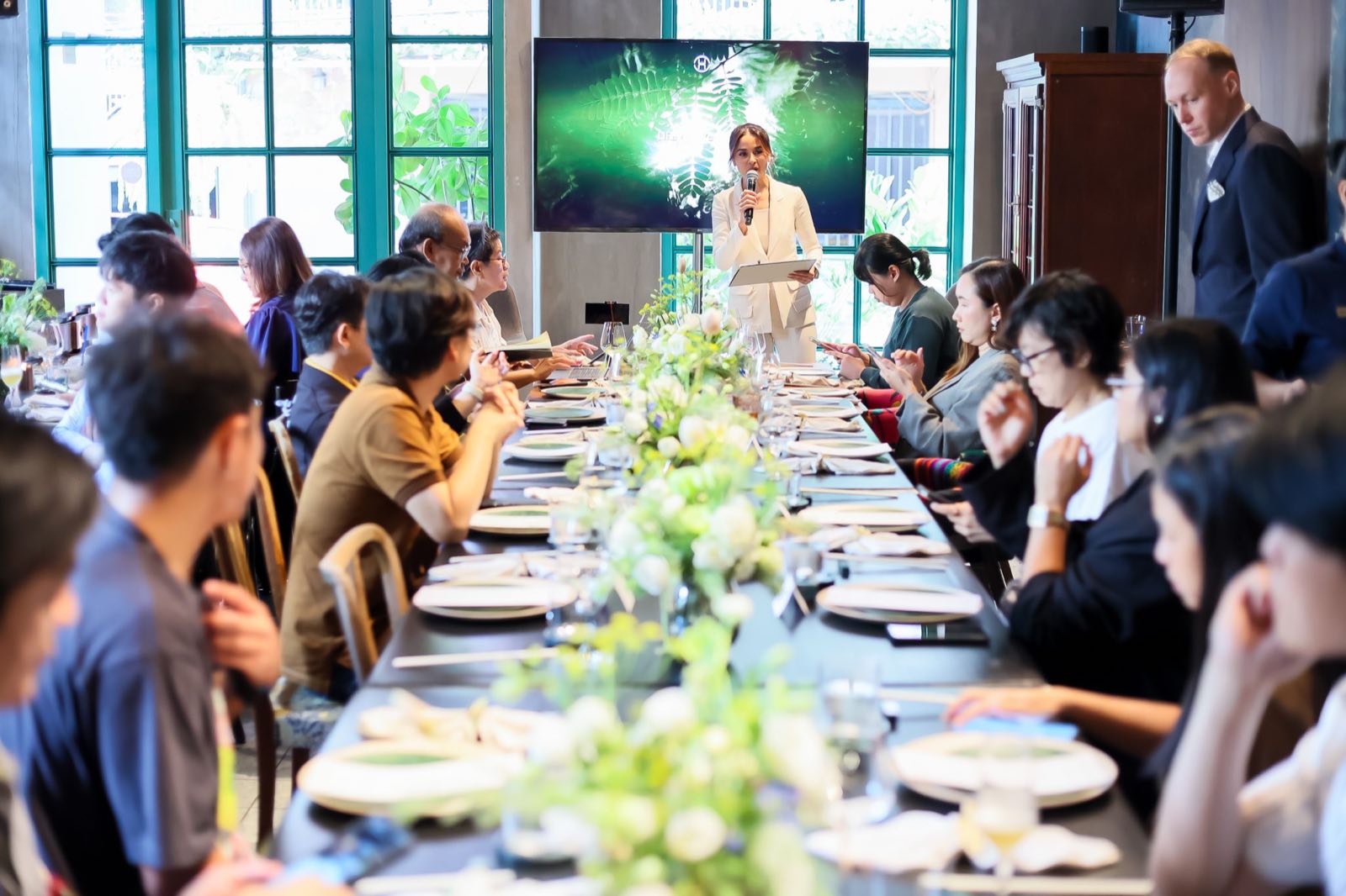 Upper House Residences Bangkok 推出晚宴上,主持人正在致辭,賓客沿鋪滿鮮花的長桌而坐