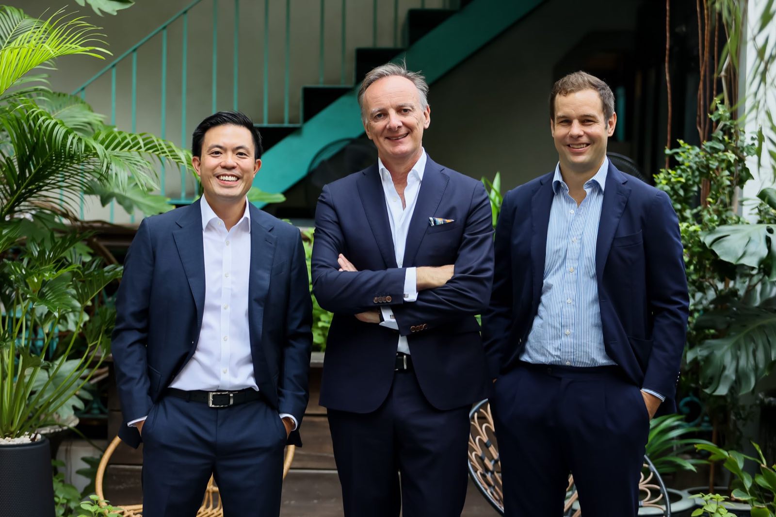 City Realty 與 Swire 的三位高層身穿深藍西裝,出席曼谷 Upper House Residences 的發布活動,場地是曼谷一處綠意庭園