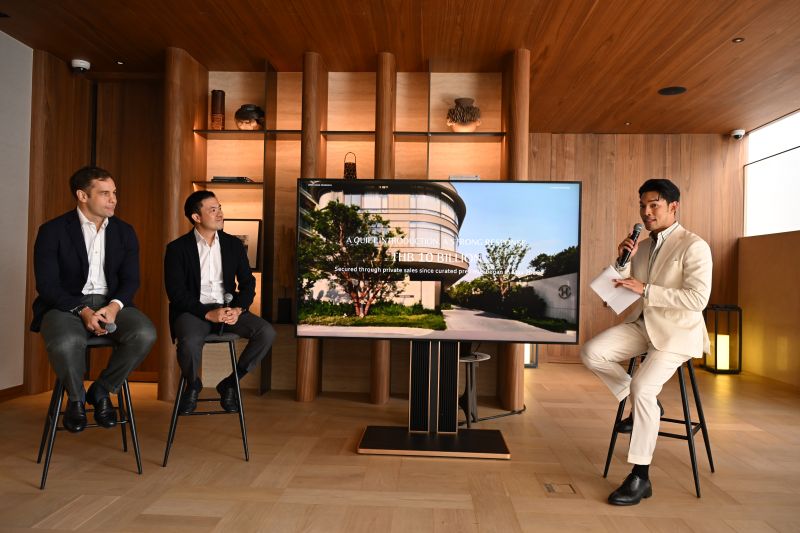 Three speakers on stools discuss Upper House Residences Bangkok beside a screen showing a render of the development among trees