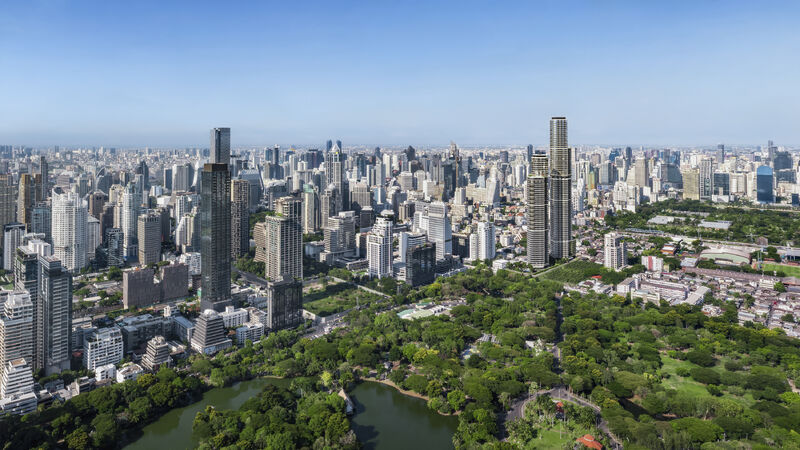 Upper House Residences Bangkok and The Wireless Residences by Upper House, the two towers rising on Wireless Road beside the lake and trees of Lumphini Park, with the central Bangkok skyline around them, an artist's impression