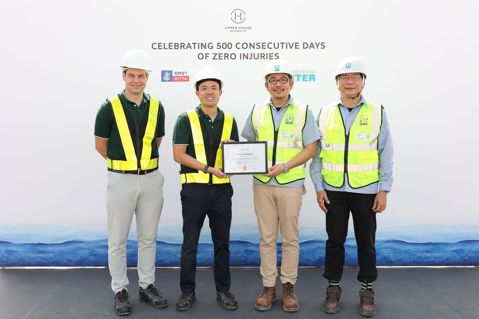 曼谷 Wireless Road 上 Upper House Residences 的 Zero LTI Award 頒發儀式:Swire Properties 與 City Realty 團隊與承建商並立,背景板寫著連續 500 天零工傷,並印有 RITTA 與 Stonehenge Inter 的標誌