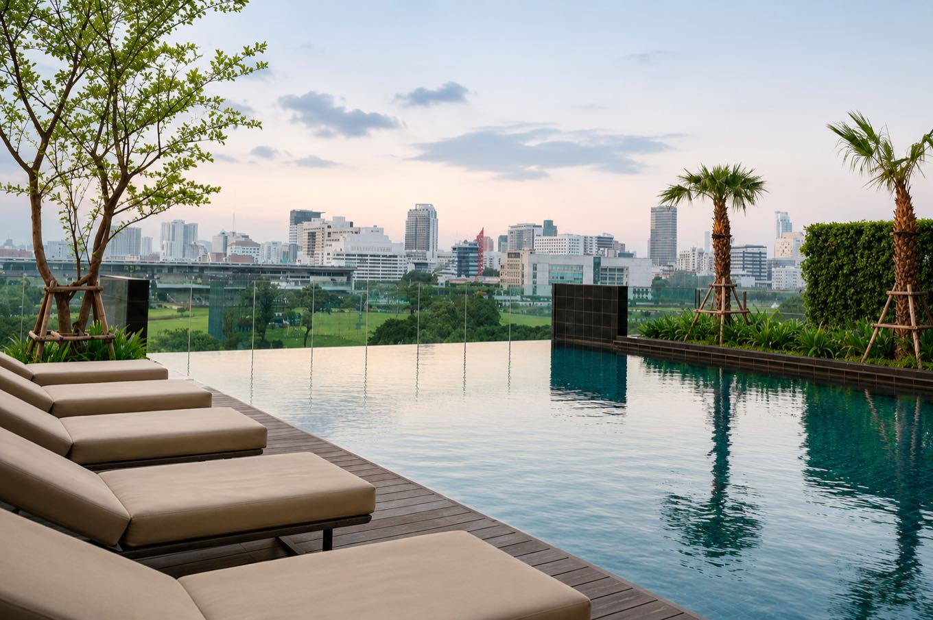 185 Rajadamri: the rooftop infinity pool and sun loungers overlooking the Royal Bangkok Sports Club racecourse