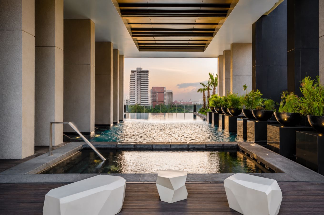 185 Rajadamri: the rooftop swimming pool and jacuzzi with the central Bangkok skyline at dusk