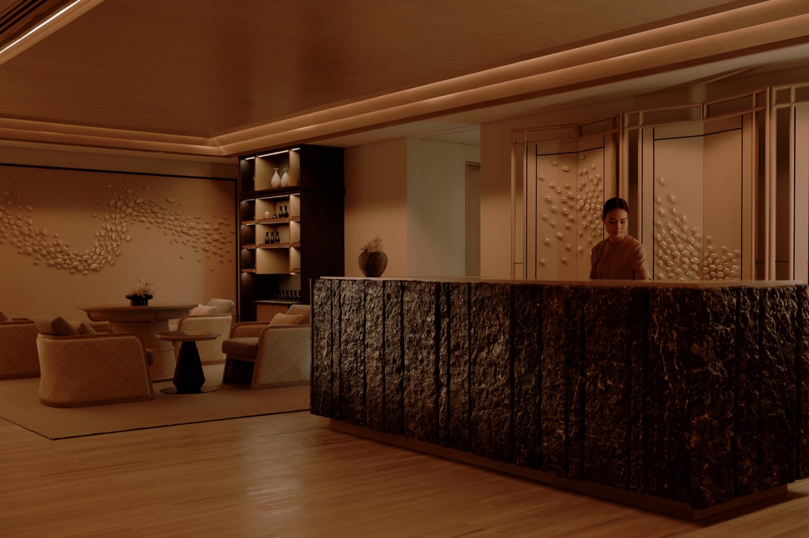 Aman Nai Lert Residences: Aman Spa reception and relaxation lounge with warm lighting and a textured stone reception desk at Aman Nai Lert Bangkok