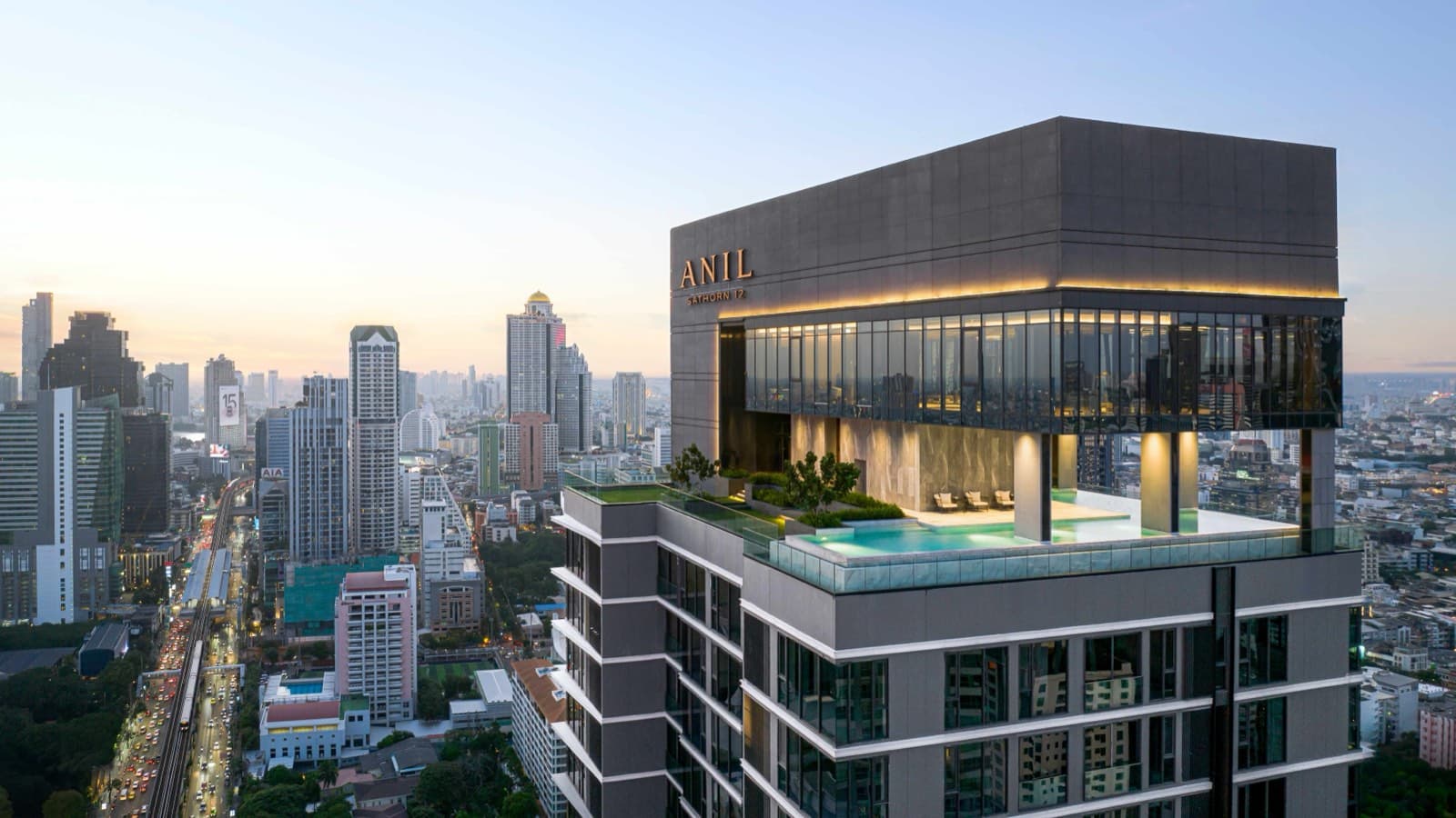 The ANIL Sathorn 12 tower crown and rooftop sky pool above the Sathorn skyline in Bangkok, by Grand Unity