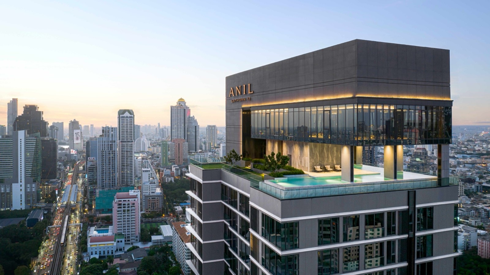 The ANIL Sathorn 12 tower crown and rooftop sky pool above the Sathorn skyline in Bangkok, by Grand Unity