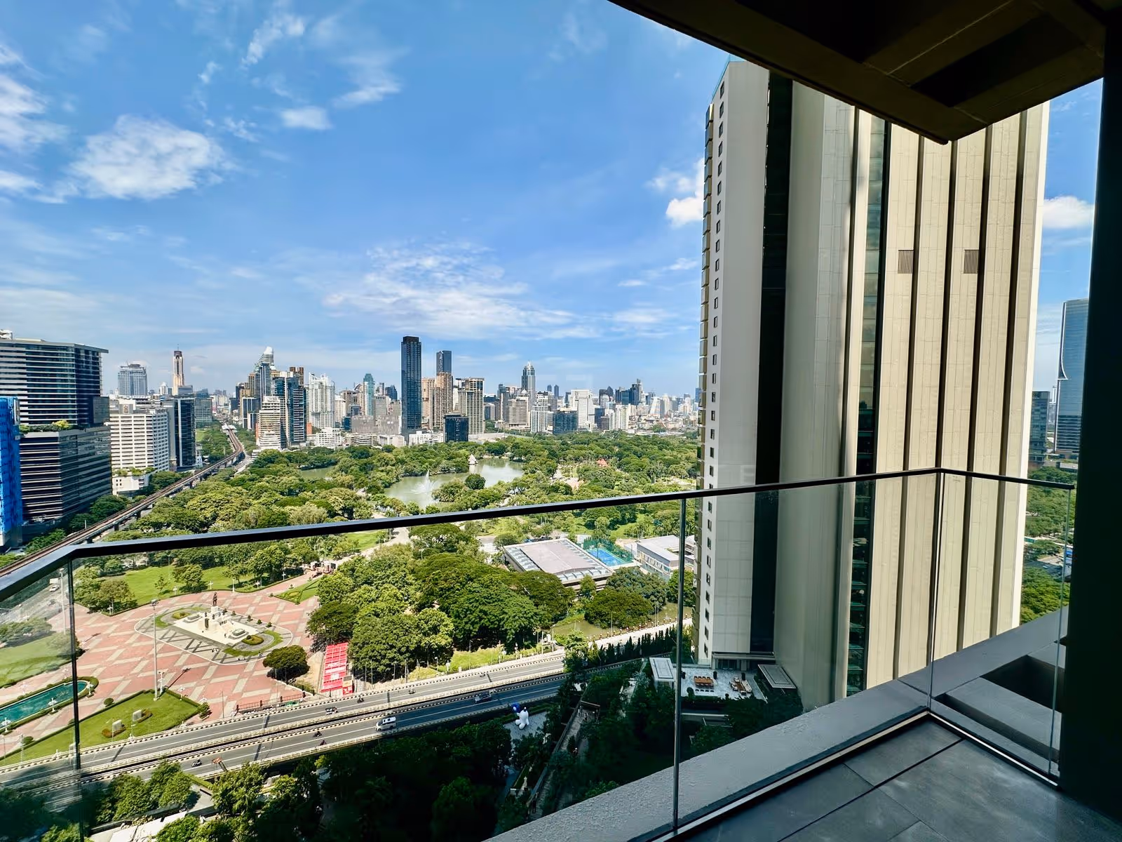 The view from the balcony of the duplex at Dusit Parkside, Dusit Central Park over Lumphini Park, its lake, the King Rama VI monument and the Silom and Sukhumvit skyline