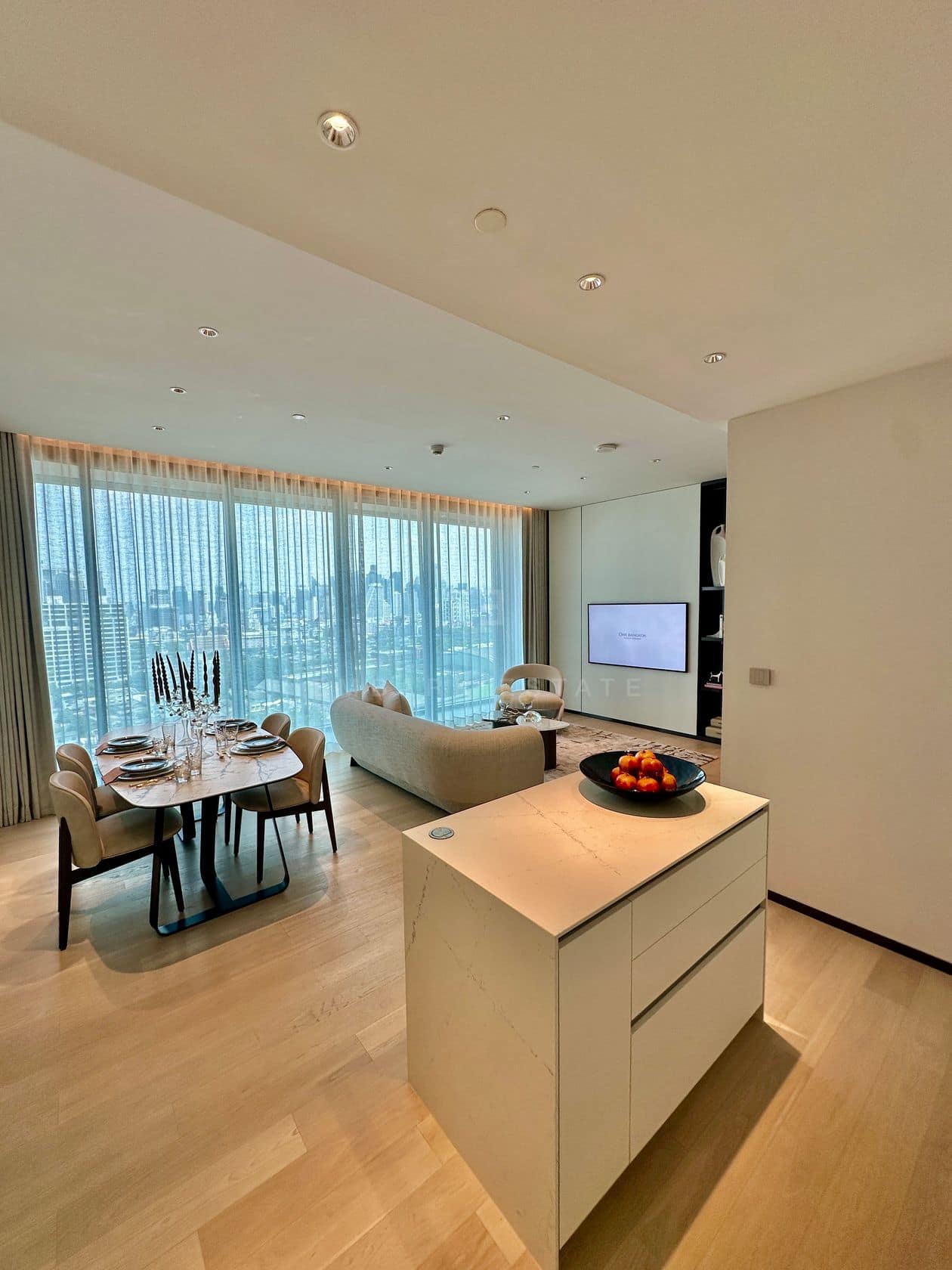 The living and dining area of a two-bedroom residence at EI8HTEEN SEVEN, One Bangkok, with a city view