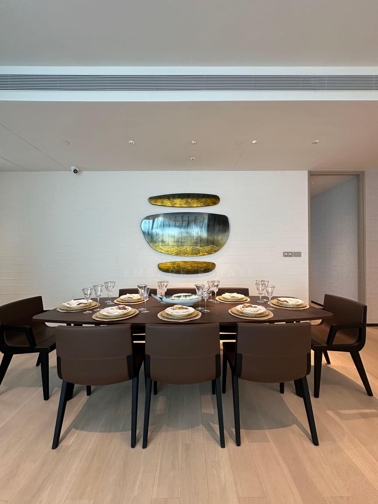 The dining room of a three-bedroom residence at EI8HTEEN SEVEN, One Bangkok, with a styled table and wall art