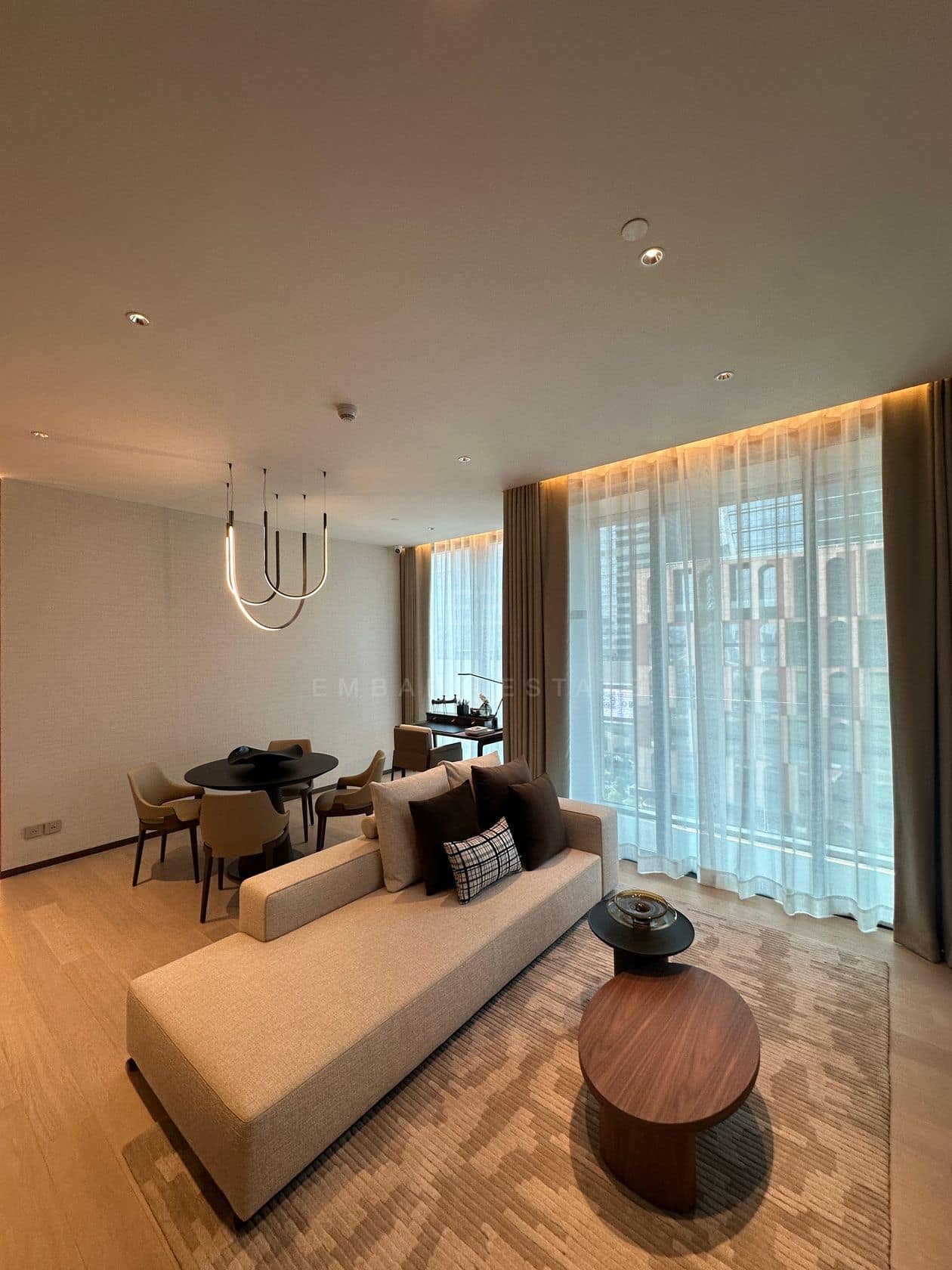 The living room of a one-bedroom residence at EI8HTEEN SEVEN, One Bangkok, with a sofa and a walnut coffee table