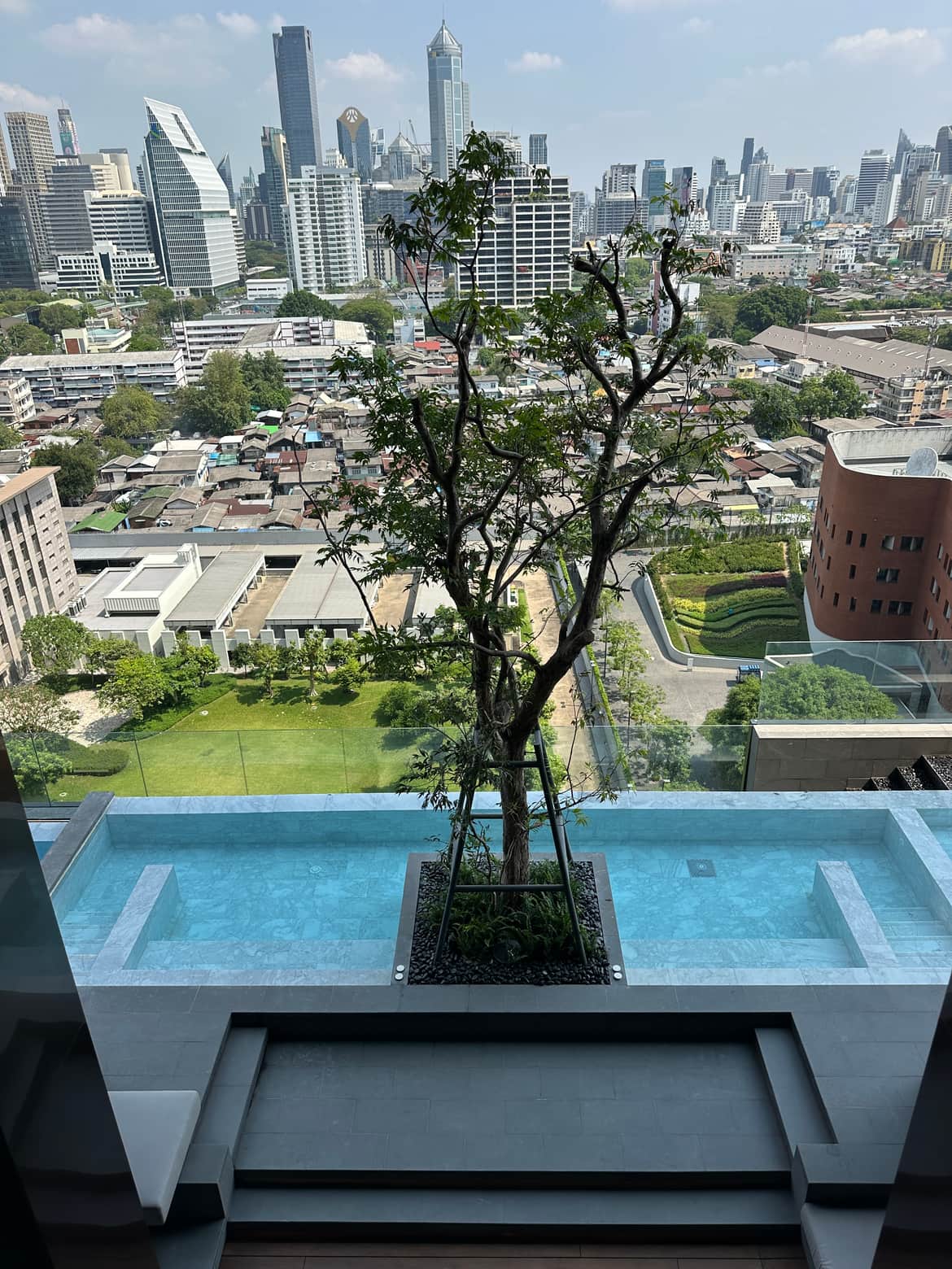 The infinity-edge swimming pool at EI8HTEEN SEVEN, One Bangkok, overlooking Lumphini Park and the Bangkok skyline