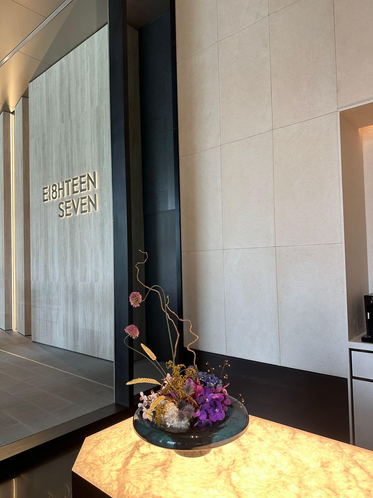 The residents' reception at EI8HTEEN SEVEN, One Bangkok, with the etched EI8HTEEN SEVEN name wall