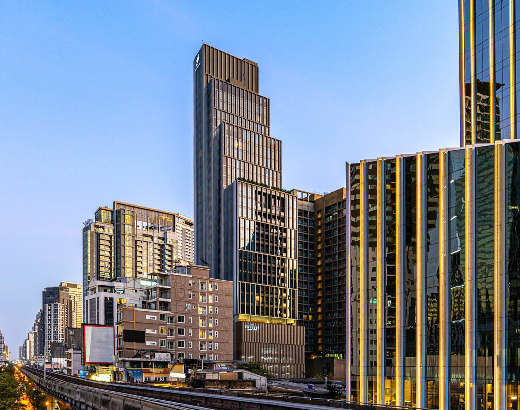 The Estelle Phrom Phong: the tower facade above the Sukhumvit streetscape at dusk