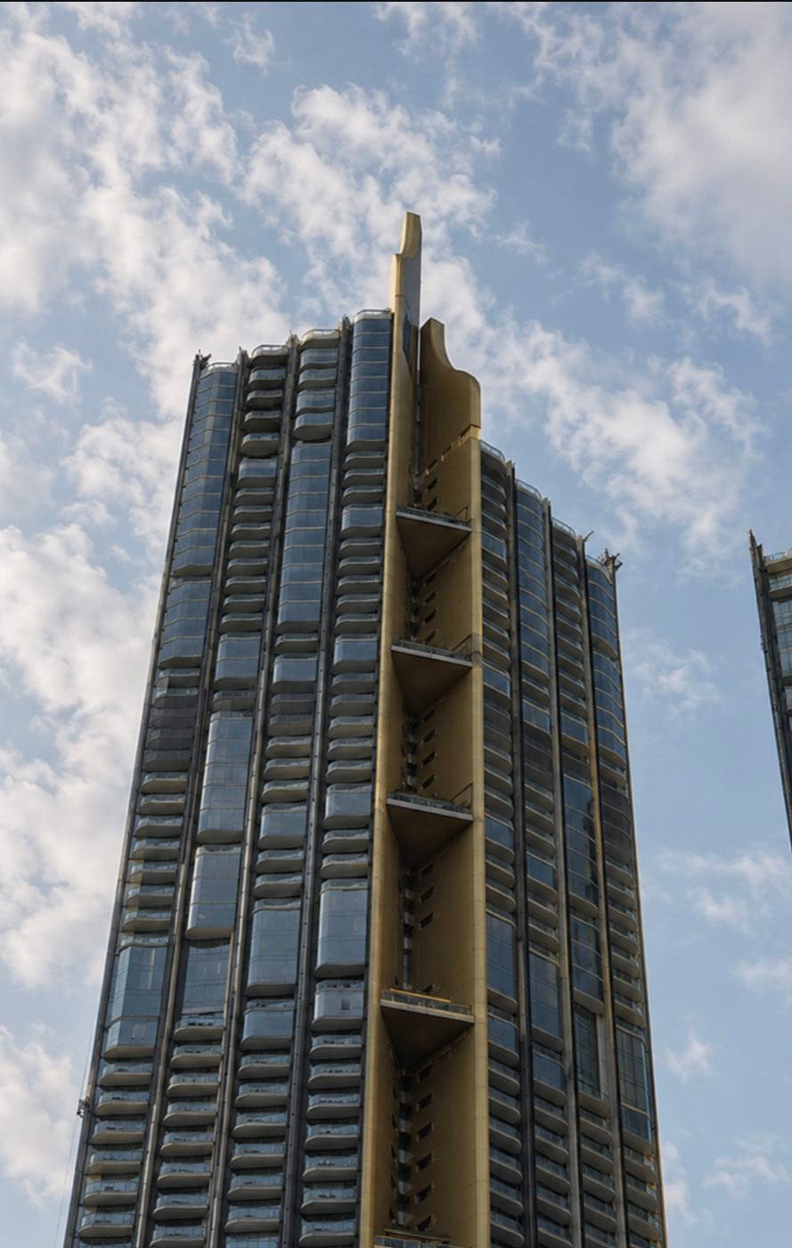 Magnolias Waterfront Residences: the sculptural gold-finned crown of the riverside tower at ICONSIAM against the sky in Bangkok, by MQDC
