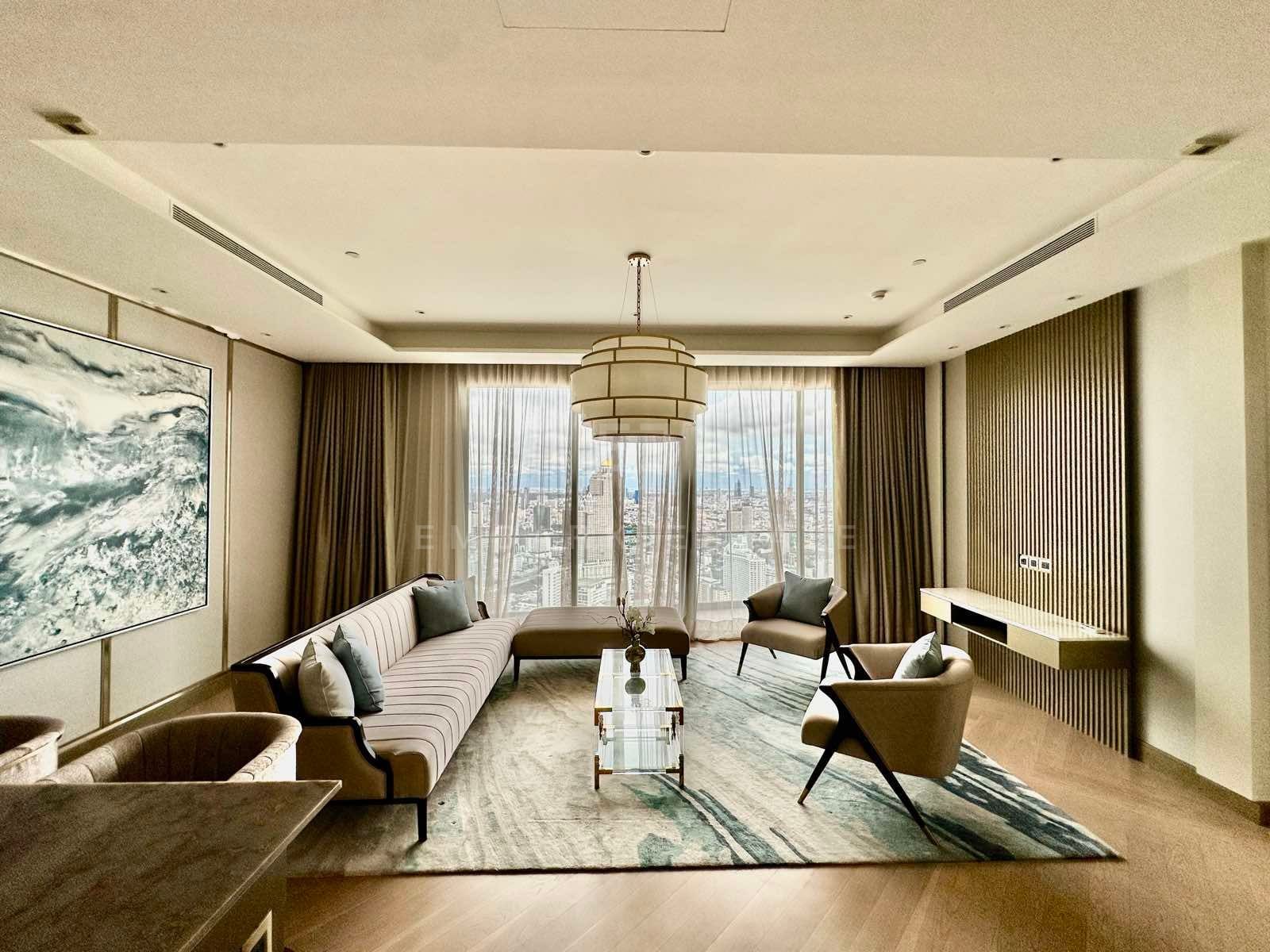 Formal sitting room with a striped sofa, two armchairs, a tiered drum pendant, a large abstract canvas, and floor-to-ceiling windows behind sheer curtains, Mandarin Oriental Residences Bangkok.