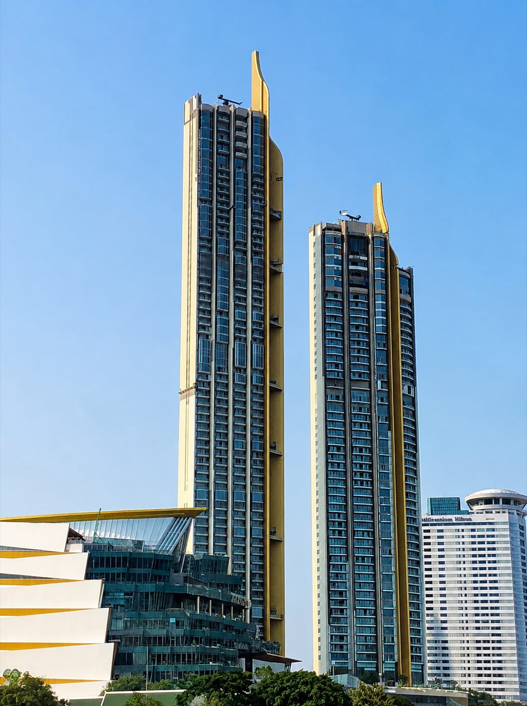 The Residences at Mandarin Oriental Bangkok: the two gold-finned riverside towers rising above the Chao Phraya River, beside the Millennium Hilton, in Bangkok