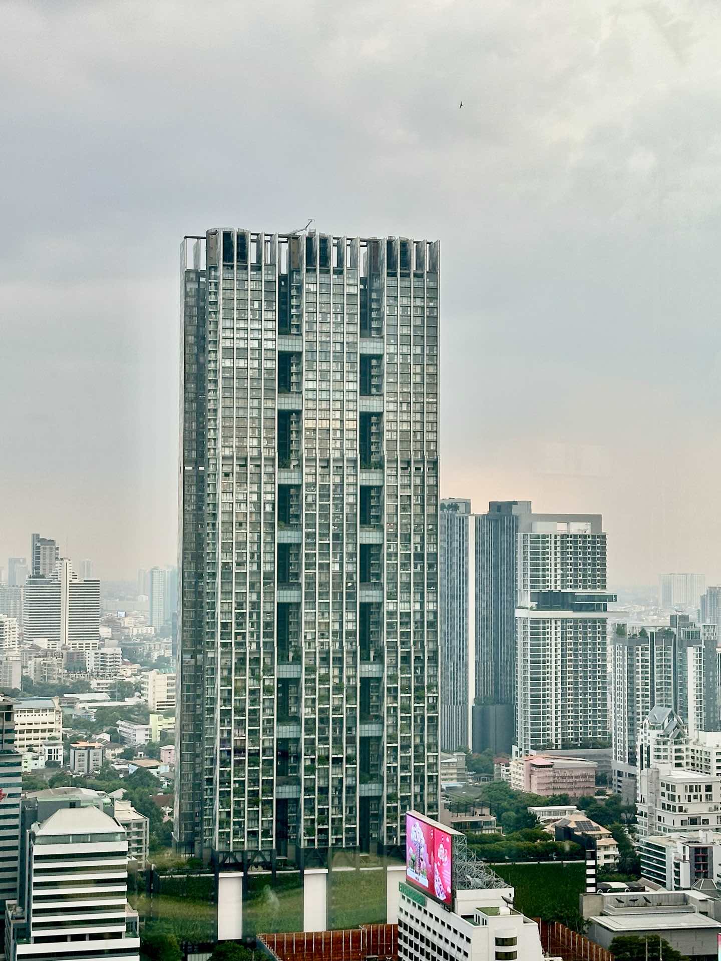 The Met Sathorn: the tower's perforated facade seen from street level