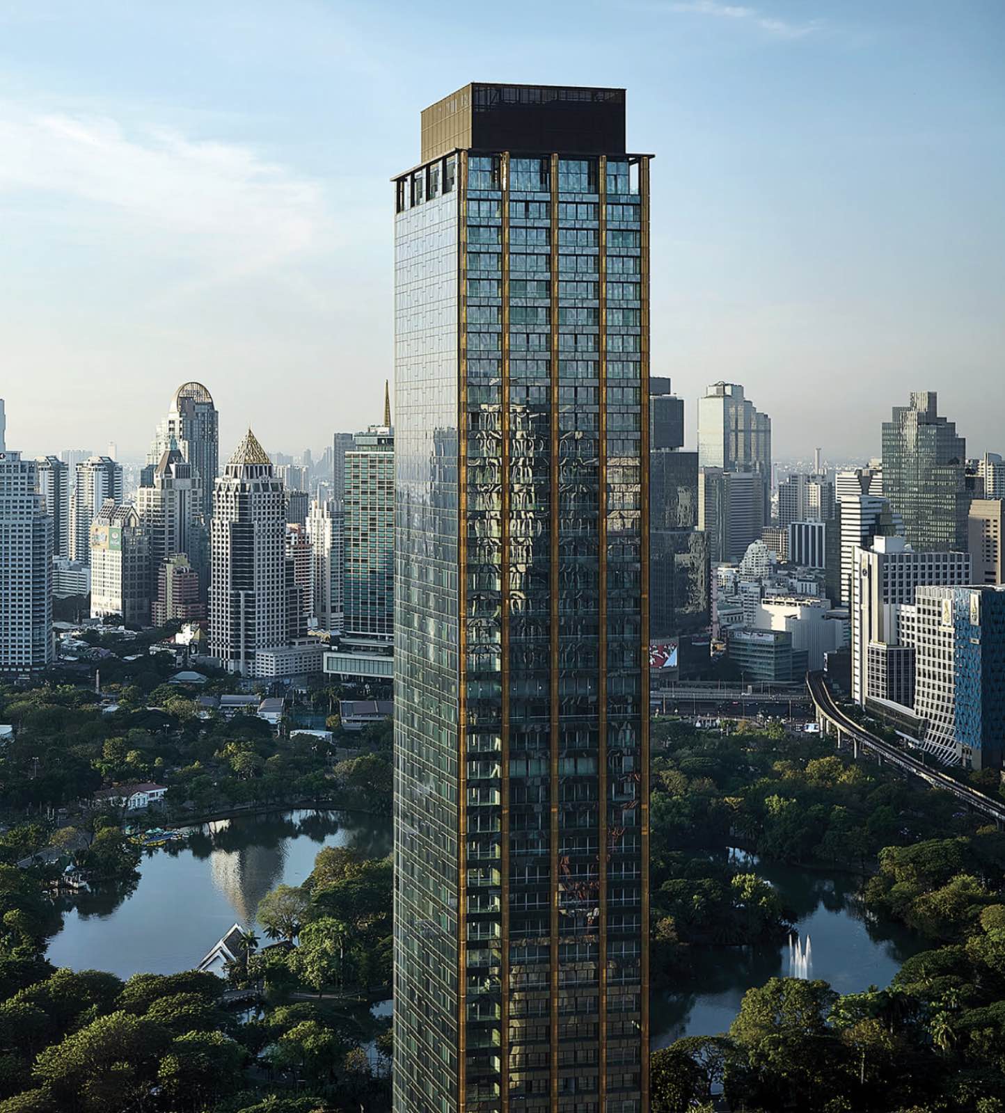 NIMIT Lumphini Park North tower in daylight above Lumphini Park and the central Bangkok skyline