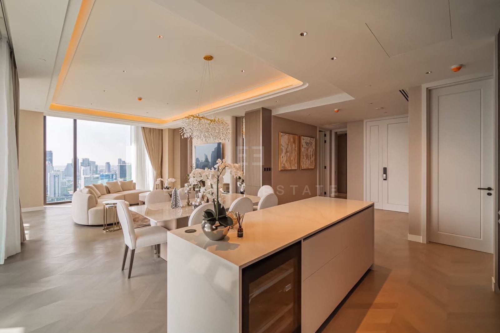 The open-plan living, dining and kitchen of a three-bedroom residence at ONE89 Wireless, One Bangkok, with a marble island and floor-to-ceiling views over Lumphini Park and the central Bangkok skyline