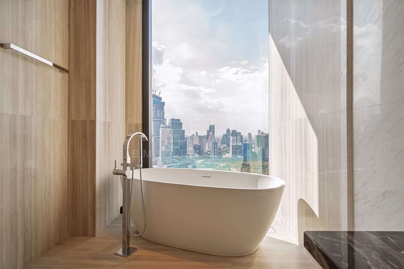 The marble principal bathroom of a three-bedroom residence at ONE89 Wireless, One Bangkok, with a double vanity, freestanding bath and floor-to-ceiling skyline views